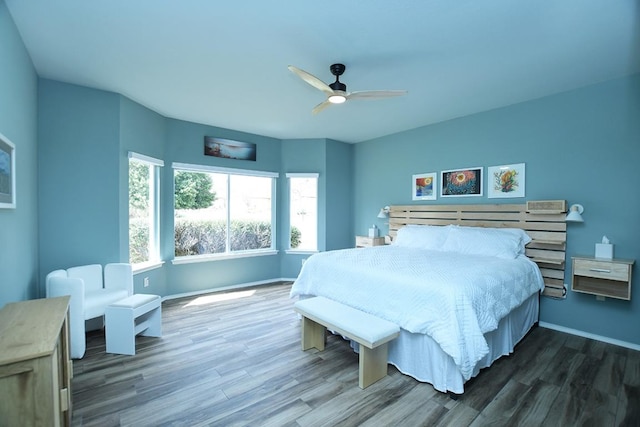 bedroom with ceiling fan, wood finished floors, and baseboards