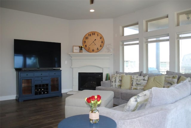 living room with baseboards, dark wood-type flooring, a fireplace, and recessed lighting