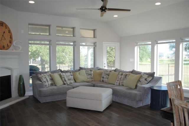 living room with a fireplace with raised hearth, recessed lighting, a ceiling fan, vaulted ceiling, and dark wood-style floors