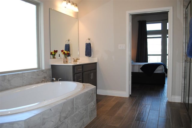 full bathroom featuring ensuite bathroom, wood finished floors, vanity, and a healthy amount of sunlight