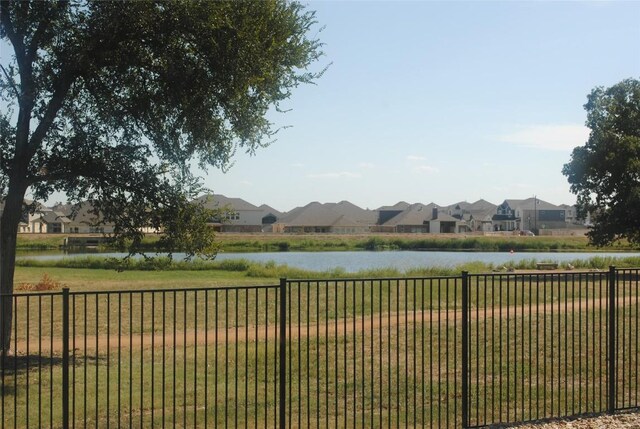 view of yard featuring a water view and fence