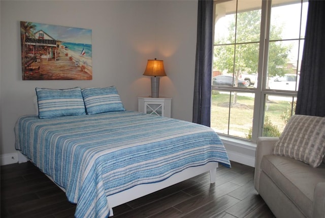 bedroom with baseboards and wood finish floors