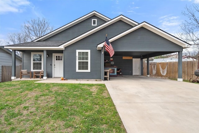 view of front of property with a front lawn, fence, a porch, concrete driveway, and a carport