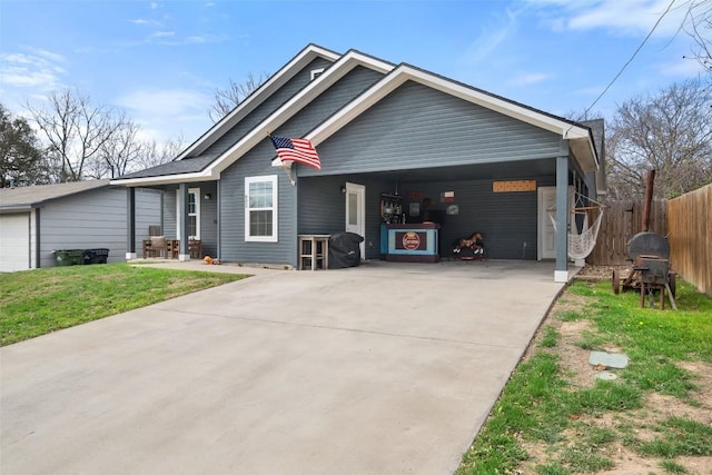 view of front of home with a garage, a front lawn, driveway, and fence