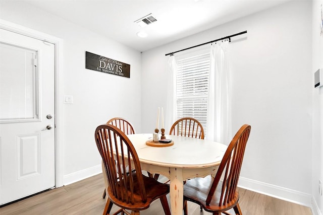 dining room featuring light wood-style flooring, baseboards, and visible vents