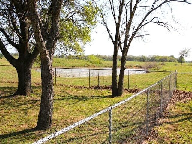 view of yard featuring a water view and fence