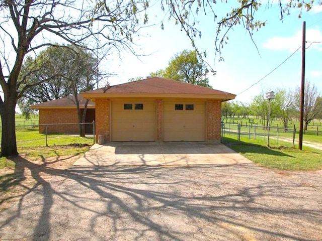 garage with fence and driveway