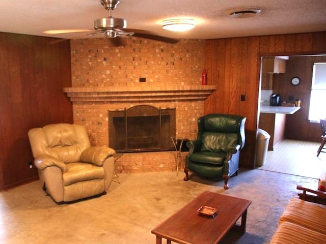 carpeted living area with wood walls, a fireplace, a textured ceiling, and ceiling fan