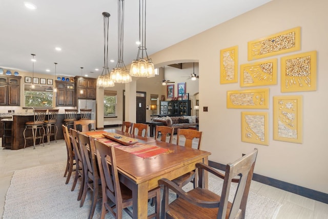 dining area featuring baseboards, light tile patterned floors, recessed lighting, arched walkways, and a ceiling fan