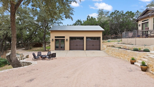 detached garage featuring french doors and fence