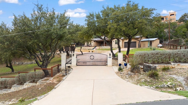 view of community featuring a gate, fence, and driveway