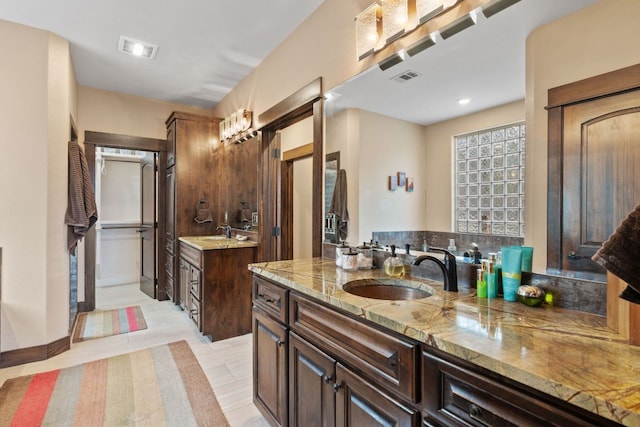 bathroom featuring two vanities, visible vents, and a sink