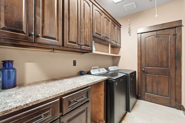 laundry room with visible vents, cabinet space, and washer and clothes dryer