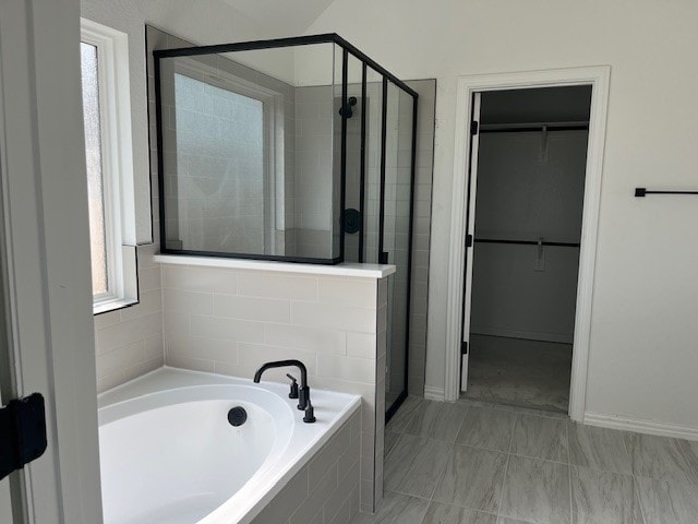 525 Teasley Dr, Taylor, TX 76574 - bathroom featuring a shower stall, a bath, and a walk in closet