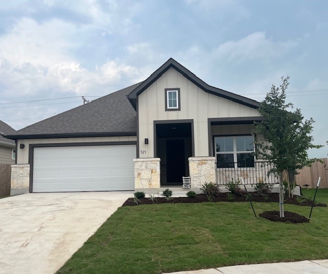 525 Teasley Dr, Taylor, TX 76574 - view of front of home featuring a garage, driveway, board and batten siding, a shingled roof, and stone siding