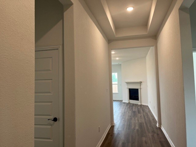 525 Teasley Dr, Taylor, TX 76574 - hallway with a textured wall, dark wood-style floors, recessed lighting, and a raised ceiling