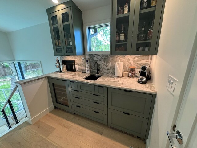 212 Westhaven Dr, West Lake Hills, TX 78746 - bar featuring light wood-style flooring, tasteful backsplash, a sink, and baseboards