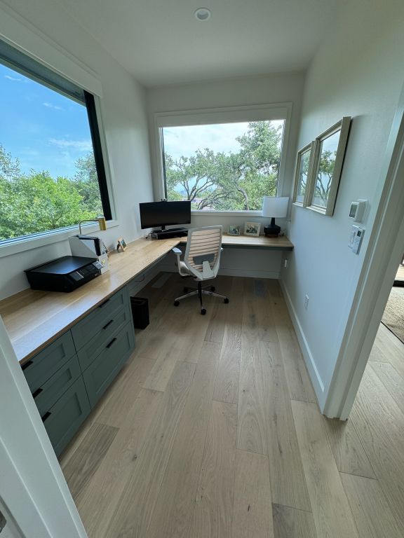 office area featuring light wood-style flooring, plenty of natural light, baseboards, and built in study area