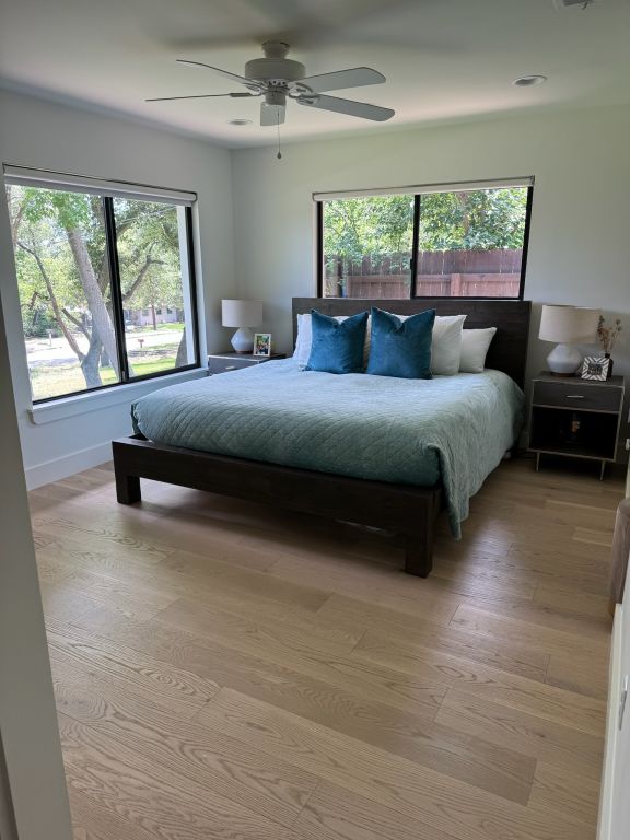 bedroom with a ceiling fan and light wood-type flooring