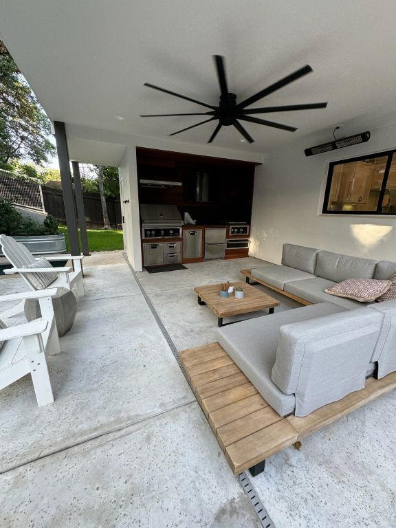 living room featuring concrete flooring and a ceiling fan