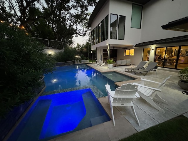 view of pool with a pool with connected hot tub, outdoor lounge area, a patio, and fence