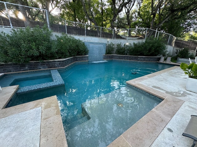 view of swimming pool with a pool with connected hot tub and a fenced backyard