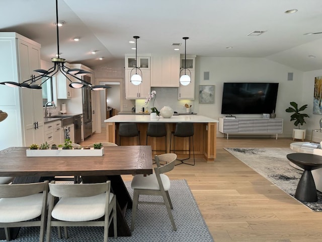 dining area featuring vaulted ceiling, light wood-style flooring, recessed lighting, and visible vents