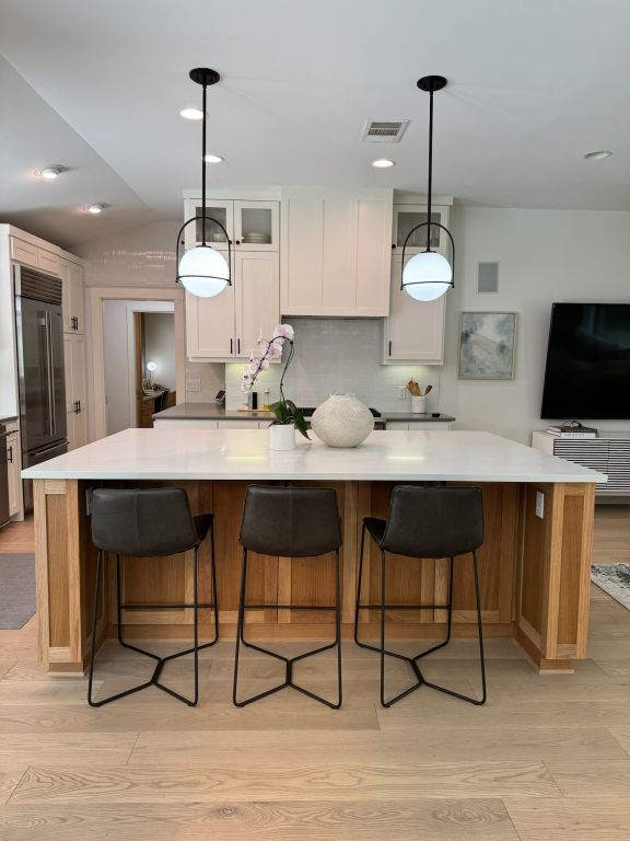 kitchen featuring high quality fridge, visible vents, light wood finished floors, and a spacious island