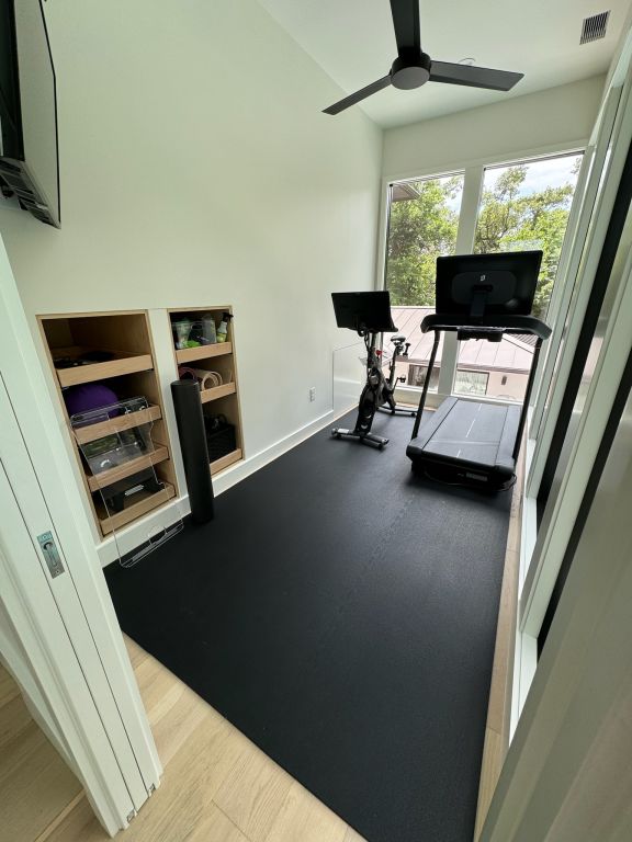 exercise room featuring visible vents, ceiling fan, and baseboards