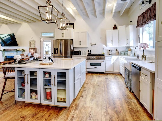 kitchen featuring a sink, light countertops, beamed ceiling, and stainless steel appliances