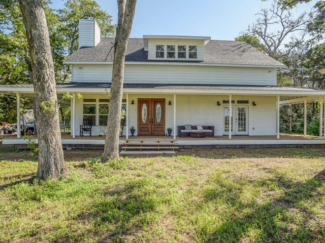 farmhouse-style home featuring french doors, a chimney, a front lawn, and roof with shingles