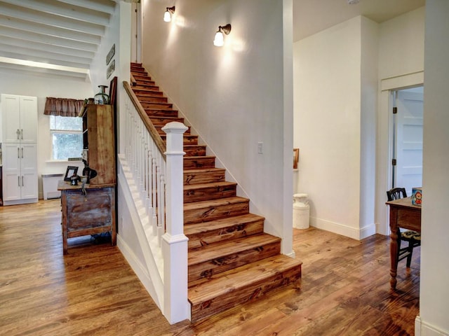 stairs featuring wood finished floors and baseboards