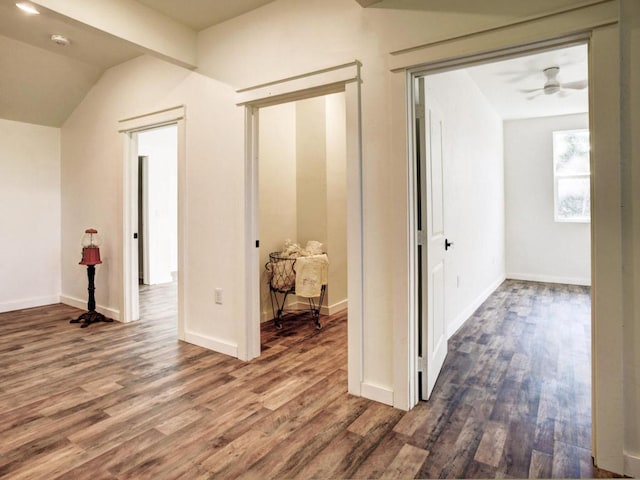 corridor featuring baseboards and wood finished floors
