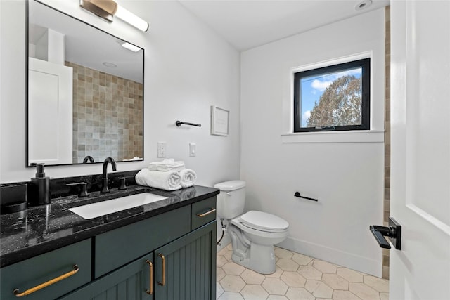 bathroom featuring vanity, tile patterned floors, toilet, and baseboards