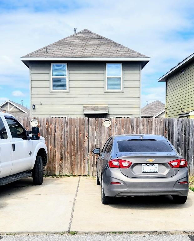 exterior space featuring a shingled roof and fence