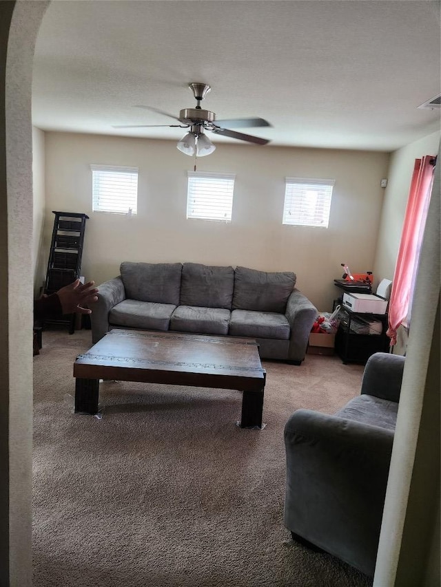 living room featuring visible vents, carpet, and a ceiling fan