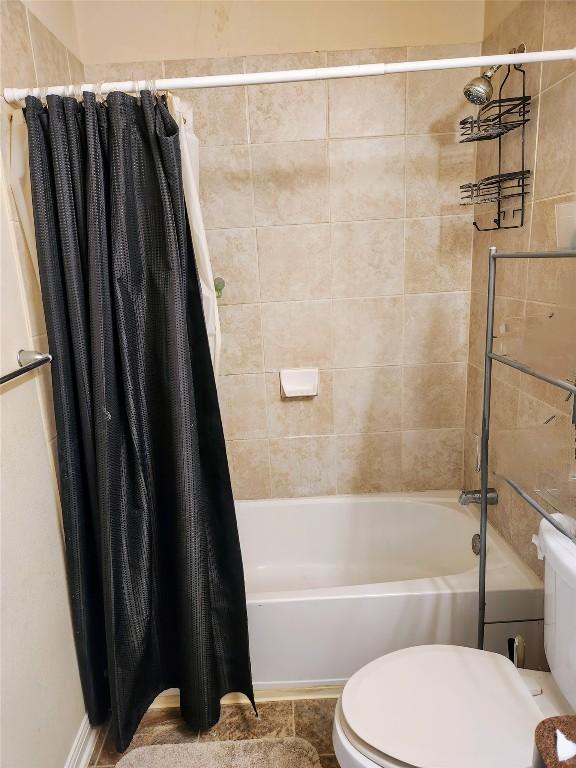 bathroom featuring shower / bath combo with shower curtain and toilet