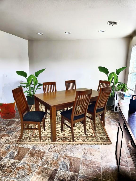 dining room featuring stone finish floor and visible vents