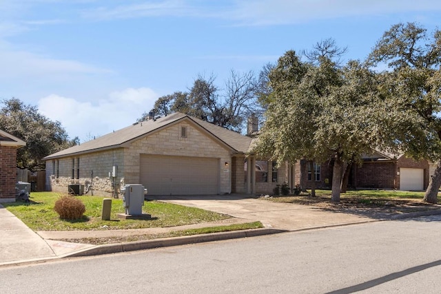 ranch-style home with concrete driveway, a garage, and stone siding