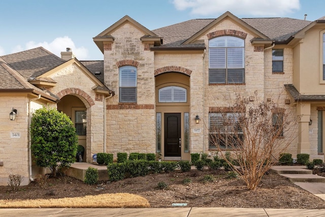 french country home with a shingled roof