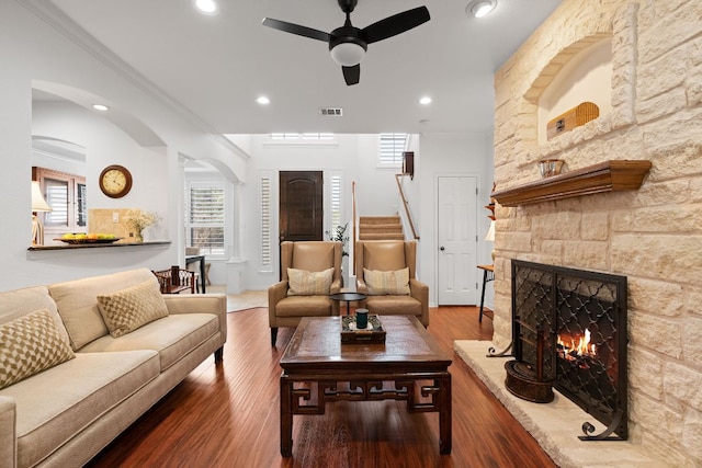 living room with arched walkways, recessed lighting, a fireplace, and wood finished floors