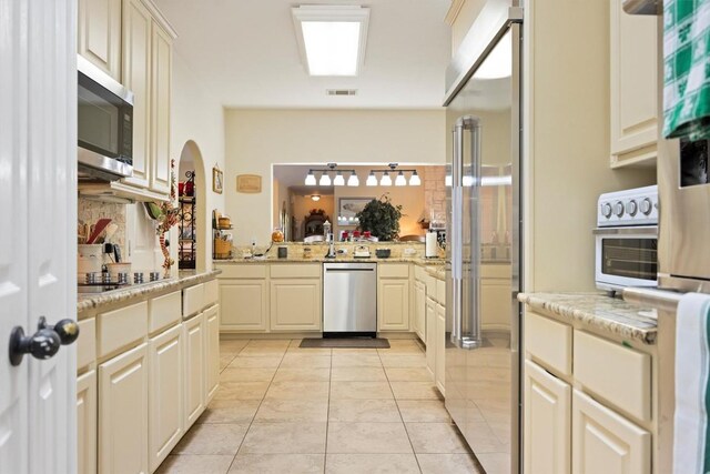 20531 Highland Lake Dr, Lago Vista, TX 78645 - kitchen with appliances with stainless steel finishes, light tile patterned floors, light stone countertops, and backsplash
