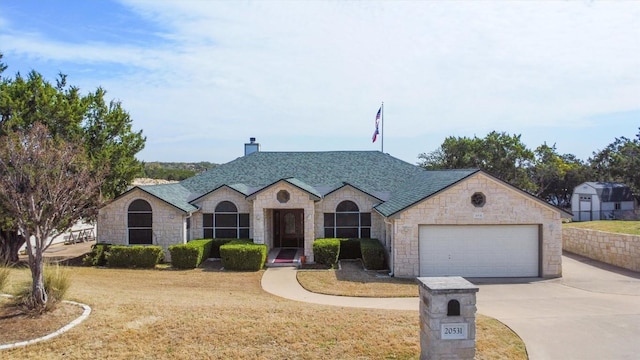 20531 Highland Lake Dr, Lago Vista, TX 78645 - french country style house featuring driveway, stone siding, a front yard, a garage, and a chimney