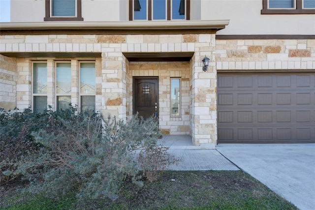 property entrance with a garage and stone siding