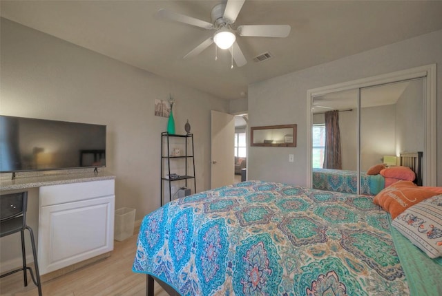 bedroom with ceiling fan, visible vents, a closet, and light wood-type flooring