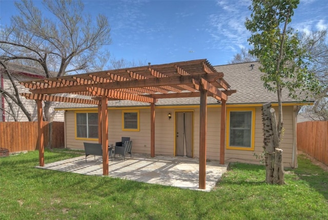 back of house featuring a yard, a patio, a fenced backyard, and a shingled roof