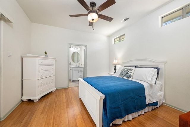 bedroom with ensuite bath, visible vents, light wood finished floors, and ceiling fan