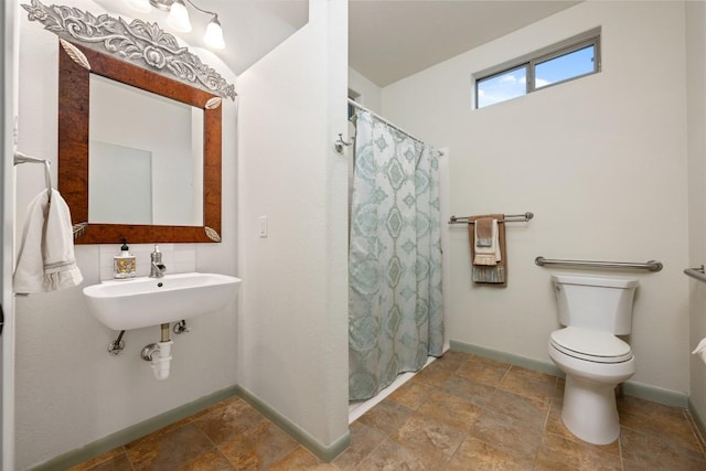 full bathroom with a shower with curtain, toilet, baseboards, and a sink