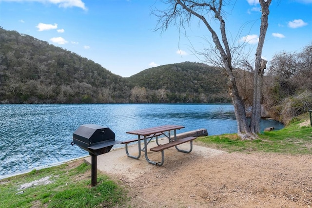 exterior space featuring a wooded view and a water and mountain view