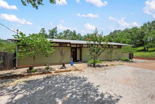 view of front of home featuring fence and metal roof